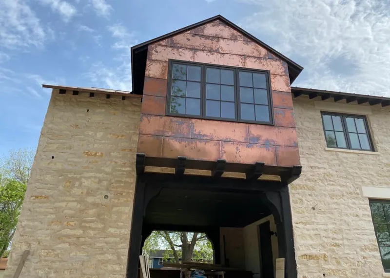 Copper metal panel facade on a stone building for Roof Repair in Caribou
