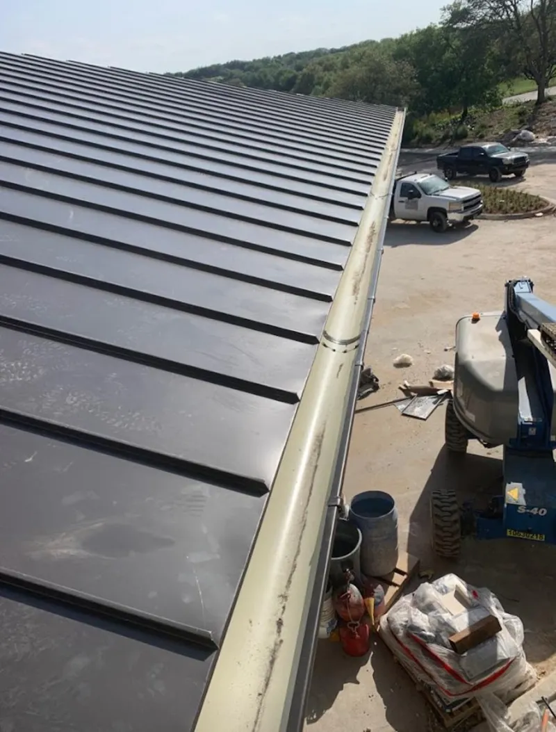 Standing seam panel and gutter detail on a metal roofing jobsite in Caribou